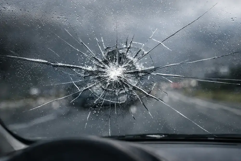 Technician replacing a cracked windshield on a vehicle in Anchorage, AK, showcasing professional auto glass repair and replacement services.